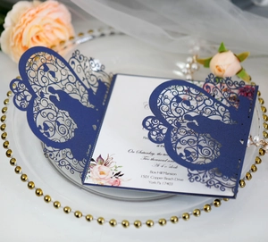 Laser-cut wedding invitation with navy blue lace cover on an elegant tray