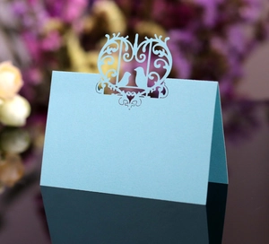 Detailed laser-cut light blue place card with heart and bird motifs for weddings