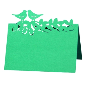 Détail du marque-place vert menthe découpé au laser avec motifs d'oiseaux et de feuilles