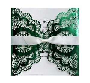 Détail d'invitation de mariage vert foncé découpée au laser avec nœud blanc et fini métal