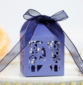 Nahaufnahme der violetten Laserschnitt-Bonbonschachtel mit Blumenmuster und blauer Schleife