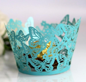 Close-up of laser-cut butterfly cupcake wrapper in teal with hollow paper design