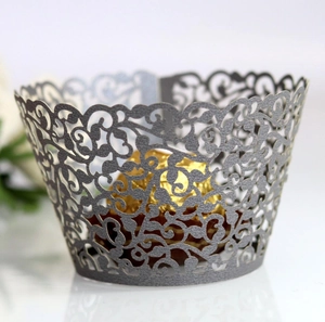Close-up of laser-cut vine patterns on pearlescent cupcake wrapper for wedding decor