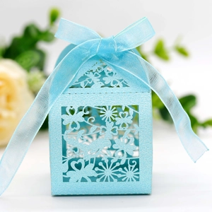 Detail of light blue laser-cut candy box with pearl texture and ribbon bow decoration