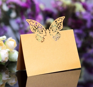 Detailed laser-cut butterfly place card in golden pearl paper for wedding table decor