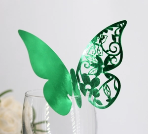 Macro shot of green butterfly place card with hollow pattern on a glass rim decoration