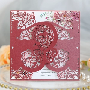 Macro detail of laser-cut wedding invitation showing intricate scrollwork patterns