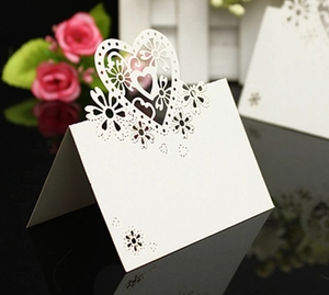 Détail du marque-place de mariage blanc découpé au laser avec motifs de cœur et fleurs