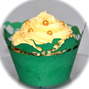 Close-up of green dinosaur cupcake wrappers featuring decorative cut-out silhouette designs