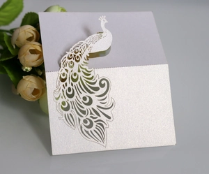 Detail of laser-cut peacock place card with pearlescent white finish and glitter texture