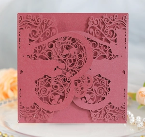 Detailed laser cut burgundy wedding invitation card with intricate lace and heart pattern