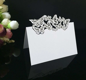 Détail de carte de table de mariage blanche pliante avec motif papillon découpé au laser