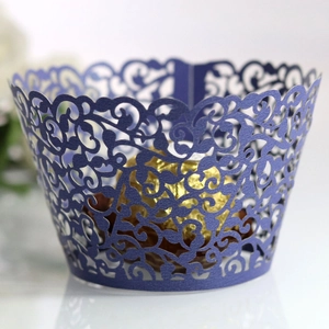 Detail of dark blue laser-cut vine cupcake wrapper with elegant hollow-out pattern