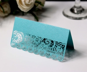 Detail of laser-cut lace pattern on bright blue pearlescent wedding place card