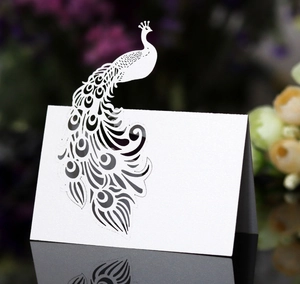 Detailed laser-cut peacock place card with intricate openwork on premium white paper