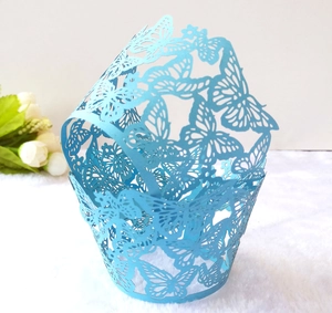 Close-up of laser-cut butterfly patterns on sky blue cupcake paper wrappers