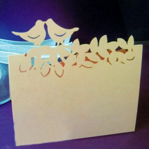 Détail du design découpé au laser avec arbre de vie et oiseaux sur carte de mariage