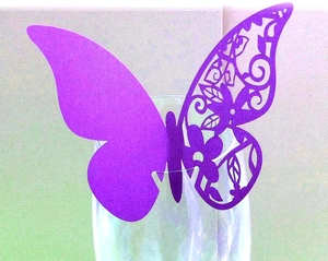 Detail of purple 3D hollow butterfly place card with laser cut floral patterns on glass rim
