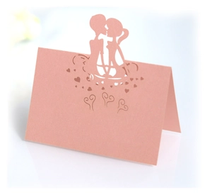 Macro detail of laser-cut pink pearl paper place card with couple silhouette
