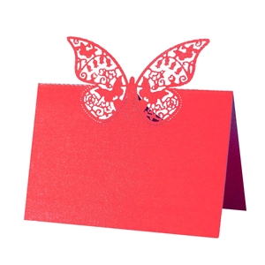 Macro shot of red laser-cut butterfly place card with intricate pearl paper texture