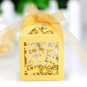 Detailed laser-cut hollow gift box with bird and floral patterns and gold ribbon bow
