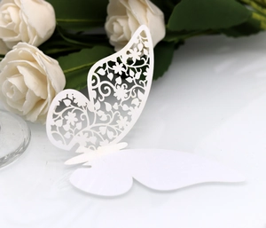 Close-up of a laser-cut white butterfly card with elegant floral hollow patterns