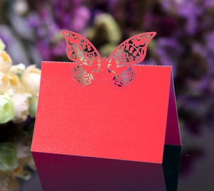Detailed laser-cut red butterfly place card with delicate floral patterns for wedding tables