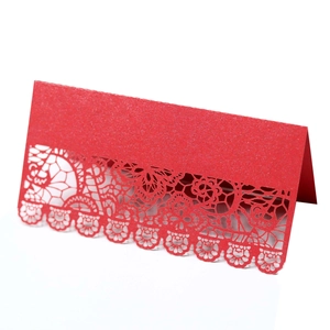Red laser-cut lace place card with floral patterns on glitter pearlescent paper