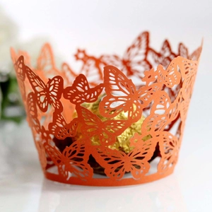 Close-up of orange laser-cut butterfly cupcake wrapper with intricate wing patterns