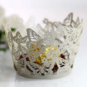 Macro view of laser-cut butterfly cupcake wrapper with intricate floral hollow patterns