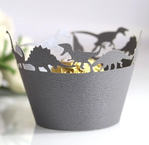 Laser-cut dinosaur cupcake wrappers in dark grey pearlescent paper with cutout silhouette