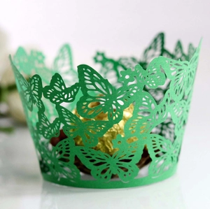 Detail of green laser-cut butterfly cupcake wrapper with intricate hollow patterns