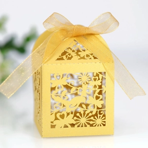 Golden laser-cut candy box with bird and flower patterns and a sheer ribbon bow