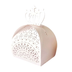 Macro view of laser-cut crown handle and lace hollow pattern on pink wedding favor box