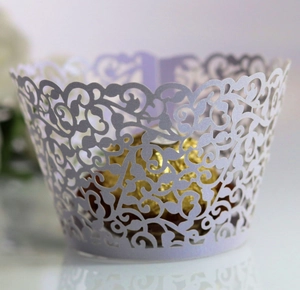 Close-up of laser-cut lavender cupcake wrapper with intricate floral vine pattern
