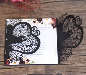 Detail of laser-cut black heart wedding invitation with red floral inner card