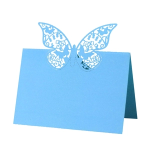 Macro detail of laser-cut butterfly design on light blue paper wedding table card