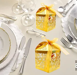 Detailed laser-cut gold candy box with floral patterns and yellow satin ribbon