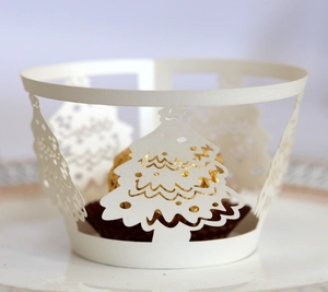 Macro detail of laser-cut white Christmas tree cupcake wrapper with pearlescent finish