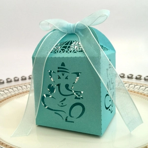 Laser cut gift box with Ganesha pattern and light blue ribbon on elegant white plate