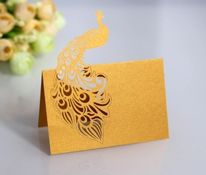 Detail of laser-cut gold peacock place card with metallic shimmer for wedding tables