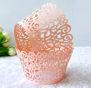 Pink laser-cut cupcake wrappers with elegant vine patterns for wedding party decor