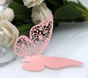 Detail of pink laser-cut paper butterfly with intricate floral hollow pattern
