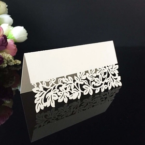 Marque-place de mariage découpé au laser avec motifs floraux blancs sur fond sombre