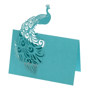 Detail of laser-cut teal peacock place card with intricate镂空patterns and fold design