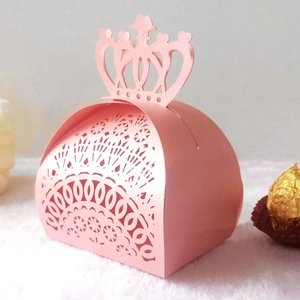 Detail of pink laser-cut crown candy box with intricate floral patterns on plush surface