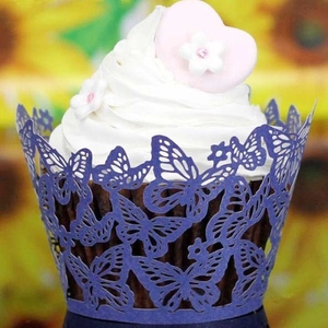 Macro shot of laser-cut butterfly lace patterns on a purple cupcake wrapper for weddings