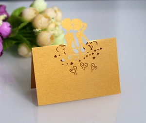 Detail of laser-cut gold wedding place card featuring a romantic couple silhouette