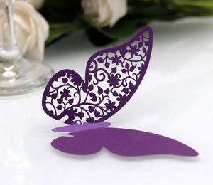 Macro detail of laser cut purple paper butterfly with intricate floral wing patterns
