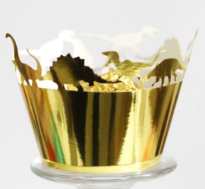 Close-up of golden dinosaur silhouette cupcake wrappers with shiny metallic mirror finish
